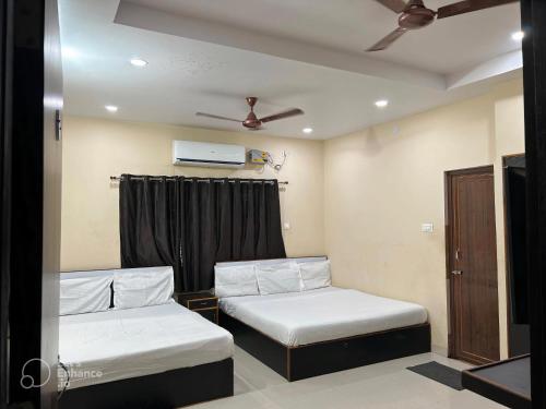 a room with two beds and a window at Archie Oasis in Bhubaneshwar