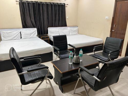 a room with two beds and a table and chairs at Archie Oasis in Bhubaneshwar