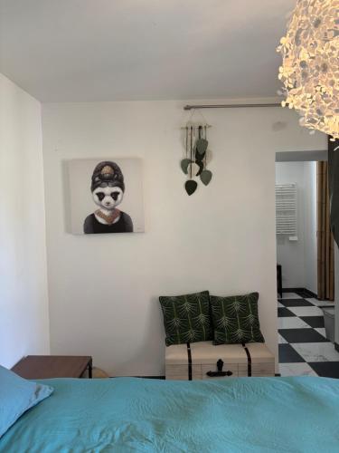 une chambre avec un lit et une photo d'un clown dans l'établissement Reve de Panda avec Sauna et Jacuzzi Privatif, à Abrest