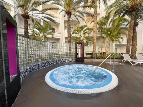a hot tub in the middle of a courtyard with palm trees at Servatur Don Miguel - Adults Only in Playa del Ingles