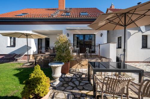 a patio with a table and chairs and an umbrella at Ferienhof am Trift in Bad Saarow