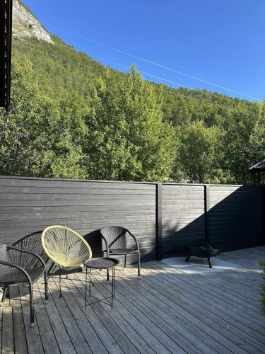 two chairs and a table and chairs on a deck at High standard and beautiful view in Tennevika