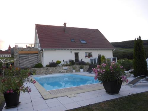 a swimming pool in front of a house at Au Coeur Du Vignoble in Orschwiller