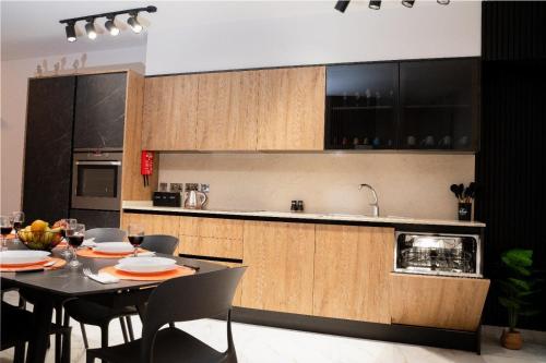 a kitchen with a table and chairs and a kitchen with cabinets at The Twin Haven Suites in Hamrun