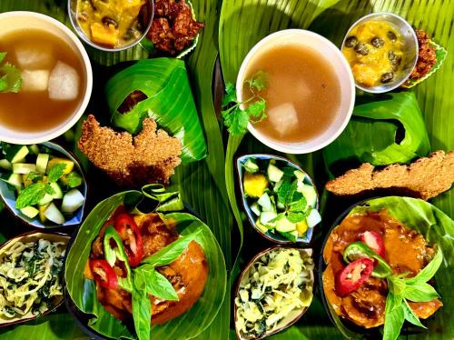 a table with plates of food and cups of tea at HAKS Boutique B&B with Pool & Farm-to-Table Dining in Lahad Datu