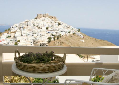 a basket on a table on a balcony with a mountain at Anatoli Luxury Studios & Suites in Astypalaia Town