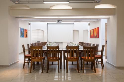 a conference room with a table and chairs and a whiteboard at OREA Hotel Arigone Olomouc in Olomouc