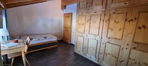 a bedroom with wooden cabinets and a bed and a table at Palü in Bever