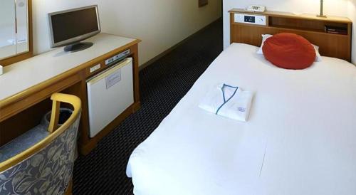 a hotel room with two beds and a television at Pearl Hotel Mizonokuchi in Yokohama