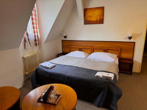 a hotel room with a bed and a table at Pension Alfa & Whisky Pub in Tábor