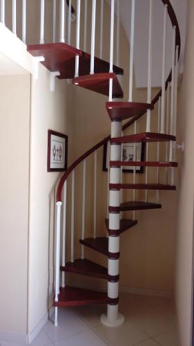 a spiral staircase with red and white railings in a house at Palazzo Muro Leccese Relais de Charme & Wellness in Muro Leccese