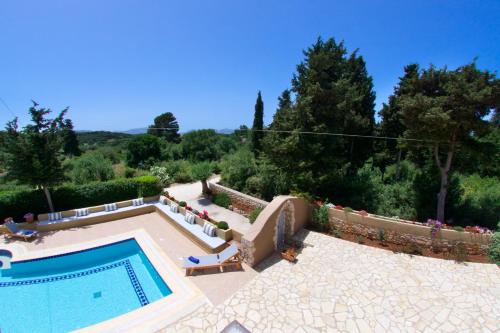 a swimming pool in a yard with trees at Villa Emily in Fiskardho