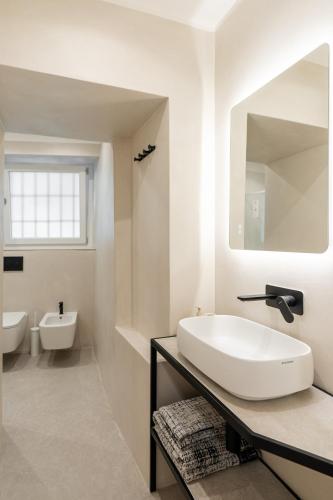 a white bathroom with a sink and a mirror at Little Suite Bellagio Da Pierina in Bellagio
