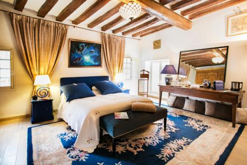 a bedroom with a large bed and a piano at Chambres d'hôtes La Bergerie de l'Aqueduc in Houx