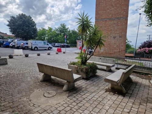 a group of benches sitting in a parking lot at La Casa del Borgo in Peccioli