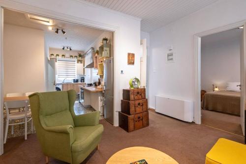 a living room with a green chair and a bedroom at Greenhouse - Kalamata Mediterranean Villas in Kalamata