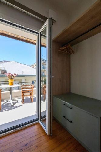 a bedroom with a sliding glass door and a balcony at Greenhouse - Kalamata Mediterranean Villas in Kalamata