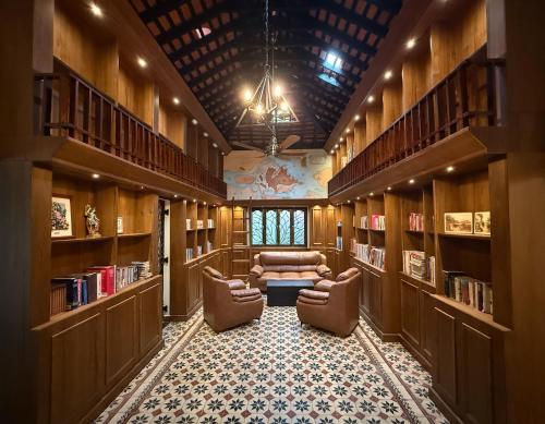 a library with two chairs and a couch in the middle at Malkin Hostel in Arpora