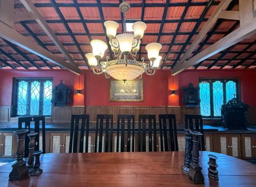 a dining room with a table and a chandelier at Malkin Hostel in Arpora