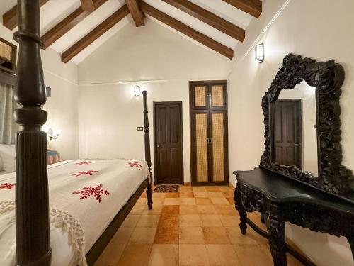 a bedroom with a bed and a large mirror at Malkin Hostel in Arpora