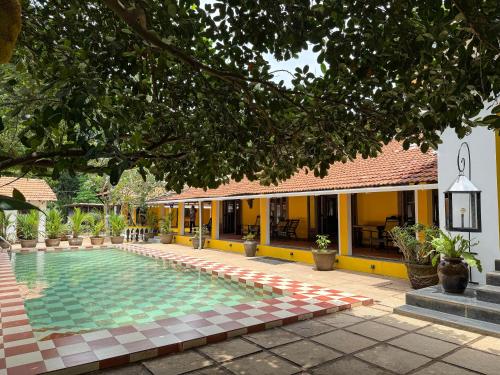a resort with a swimming pool in front of a building at Malkin Hostel in Arpora