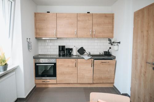 a small kitchen with wooden cabinets and a stove at Coffee Fellows Hotel Trier in Trier