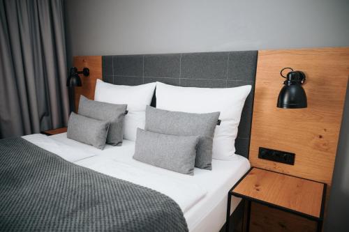 a bedroom with a bed with pillows and a lamp at Coffee Fellows Hotel Trier in Trier
