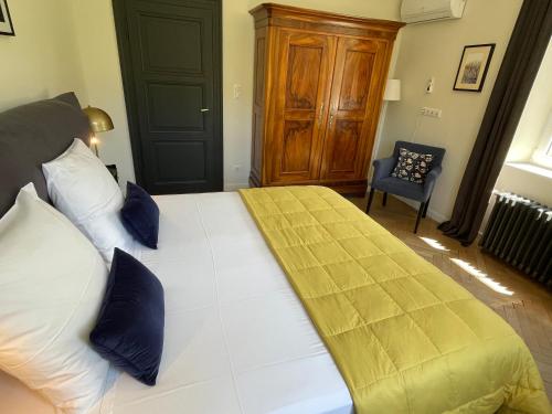 a bedroom with a large white bed with blue pillows at Le Hêtre Rouge Charme & Spa Alsace in Barr