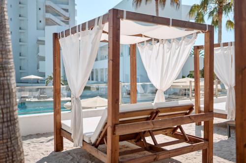 a bed on the beach next to a pool at Hotel Ankaa - Adults Only in Porto Cristo