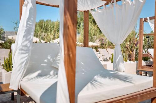 a bed with white sheets and a canopy at Hotel Ankaa - Adults Only in Porto Cristo