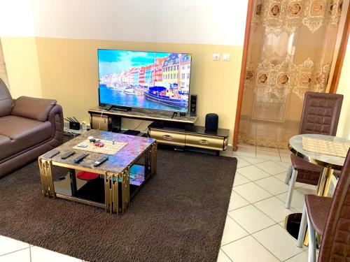 Una sala de estar con un sofá y un televisor. en Luxurious apart Mimboman Yaoundé, en Yaoundé