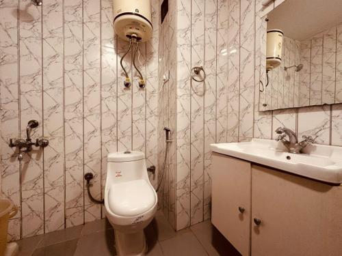 a bathroom with a toilet and a sink at Antriksh cottage Manali in Manāli