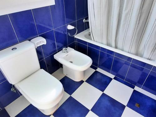 Un baño azul y blanco con inodoro y lavabo. en Apartamento tranquilo con terraza y jardín cerca de la playa - ES-170-47, en Llançà