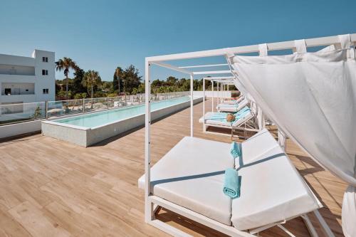 a balcony with a hammock and a swimming pool at Hotel Ankaa - Adults Only in Porto Cristo