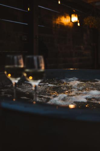 two glasses of wine sitting on top of a table at Heaven Reset Spa Luksusowy Glamping Jacuzzi w Naturze Blisko Warszawy in Korczew
