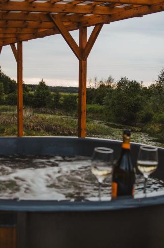two glasses of wine are sitting in a bath tub at Heaven Reset Spa Luksusowy Glamping Jacuzzi w Naturze Blisko Warszawy in Korczew
