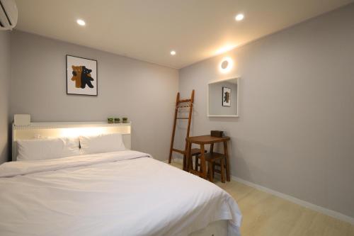 une chambre avec un lit blanc et une chaise dans l'établissement Hotel Mori, à Gwangmyeong