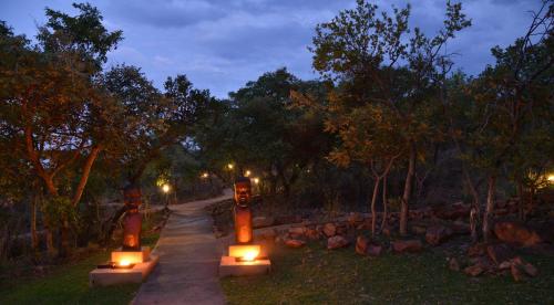 a walkway with lit candles in a park at night at Zwahili Private Game Lodge & Spa in Modimolle
