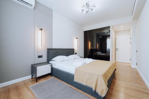 Un dormitorio con una gran cama blanca y una alfombra. en 1BR - Workspace - Park View - Elevator, en Chişinău