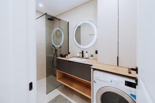 Un baño con lavabo y lavadora. en 1BR - Workspace - Park View - Elevator, en Chişinău