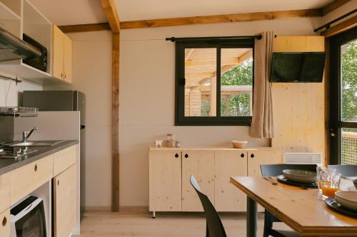 a kitchen with a wooden table and a window at Slow Village Anduze - Cévennes in Corbés