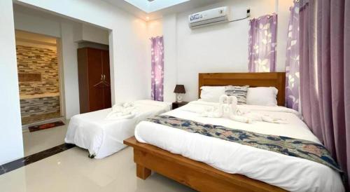 a bedroom with two beds with white sheets at Pilot Hotel in Alaminos