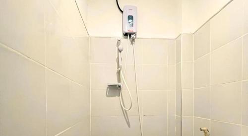 a bathroom with a shower with a cell phone on the wall at Pilot Hotel in Alaminos