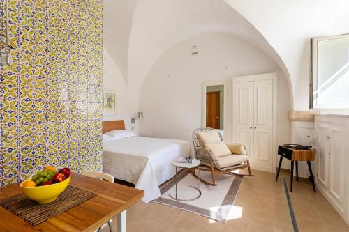a bedroom with a bed and a table with a bowl of fruit at Casa Portosalvo, Modica in Modica