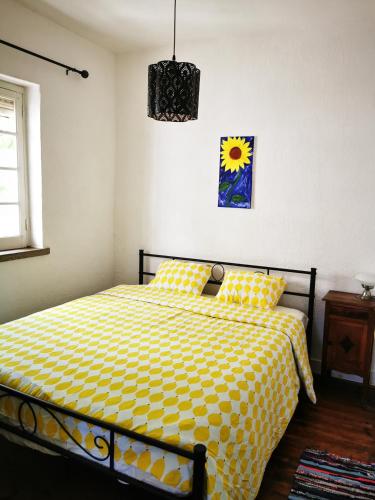a bedroom with a bed with a yellow comforter at O Ninho in Cepos