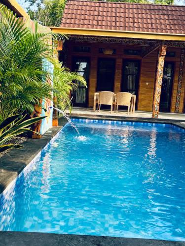a swimming pool in front of a house at Namali Villa Gili Trawangan in Gili Trawangan