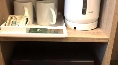 a shelf with a coffee maker and cups on it at Hotel IL FIORE Kasai in Tokyo