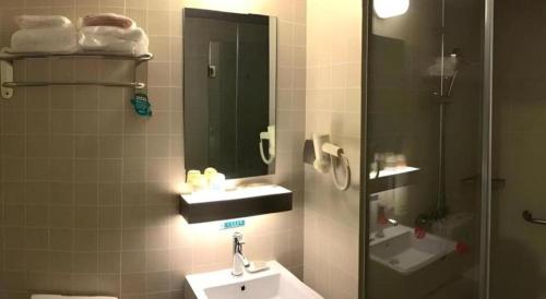 a bathroom with a sink and a mirror at Jinjiang Inn Select Shanghai Fengxian Baolong Square North Yunhe Road in Shanghai