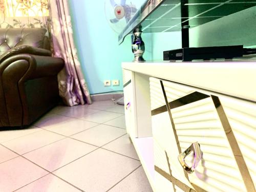 a living room with a chair and a dresser at Porche apart mimboman Yde in Kofa