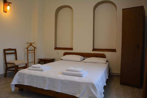 a bedroom with a bed with three towels on it at İlçayto Rooms in Foca